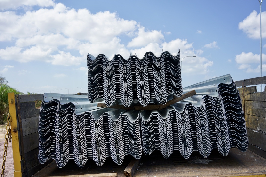 Stacks of W-beam guardrail material