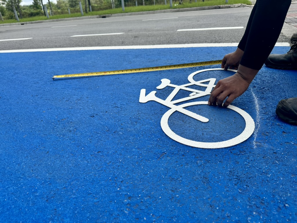 White preformed bicycle symbol positioned on blue surfacing